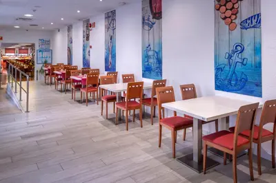 a row of tables and chairs in a restaurant at GHT Balmes, Hotel-Aparthotel&SPLASH in Calella