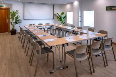a conference room with a large table and chairs at GHT Maritim in Calella