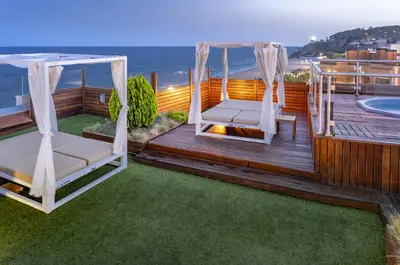 a deck with two chairs and a gazebo at GHT Maritim in Calella