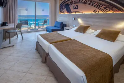 a hotel room with a large bed and a balcony at GHT Maritim in Calella