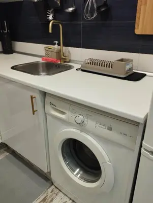 a kitchen with a sink and a washing machine at Apartment Fira Bcn Camp Nou in Hospitalet de Llobregat