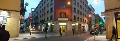 a city street at night with buildings and a car at Apartment Fira Bcn Camp Nou in Hospitalet de Llobregat