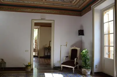 a living room with a chair and a ceiling at Piso Vilanova i la Geltrú in Vilanova i la Geltrú