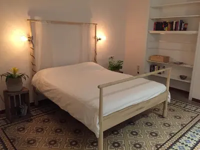 a bed in a room with a white bed frame at Piso Vilanova i la Geltrú in Vilanova i la Geltrú
