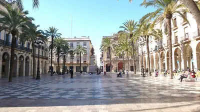 a city street with palm trees and buildings at Piso Vilanova i la Geltrú in Vilanova i la Geltrú