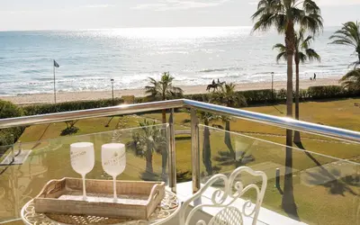a balcony with a table and chairs and the beach at Gava Beach 1st Line in Gavà