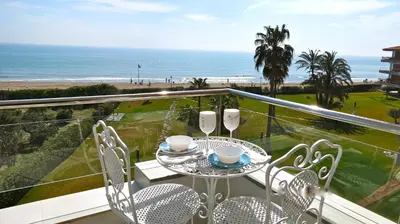 a balcony with a table and chairs and the ocean at Gava Beach 1st Line in Gavà
