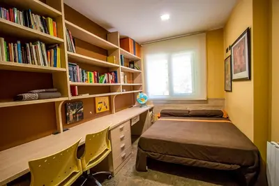 a room with a bed and a desk and bookshelves at Catalunya Casas Modern and spacious with private pool close to BCN in Senmanat