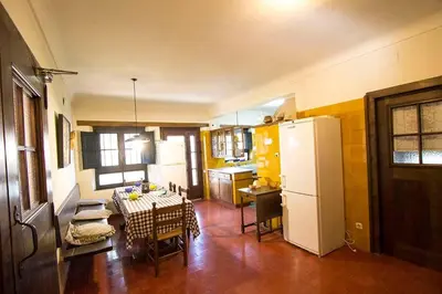 a kitchen with a table and a white refrigerator at Catalunya Casas Heavenly Haven for 16 pax , 30km from Barcelona! in Castellar