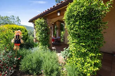 a garden with a large green hedge next to a house at Catalunya Casas Peaceful Perfection , only 30km from Barcelona! in Vacarisas