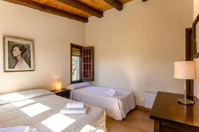 a bedroom with two beds and a table with a lamp at Catalunya Casas Nature and Tranquility for 24 pax - 30km to beach in Sant Pere de Vilamajor