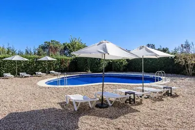 a swimming pool with umbrellas and chairs and a pool at Catalunya Casas Nature and Tranquility for 24 pax - 30km to beach in Sant Pere de Vilamajor