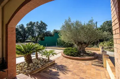 an archway with trees and plants in a courtyard at Catalunya Casas Nature and Tranquility for 24 pax - 30km to beach in Sant Pere de Vilamajor