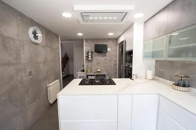a kitchen with white cabinets and a stove top oven at Catalunya Casas Mountain escape with amazing views just 25km to BCN! in Torrelles de Llobregat