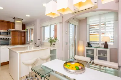 a kitchen with a glass table and a bowl of fruit at HomeHolidaysRentals Amaral in Pineda de Mar