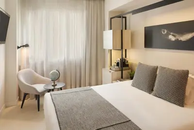 a hotel room with a bed and a chair at Hotel Denit Barcelona in Barcelona