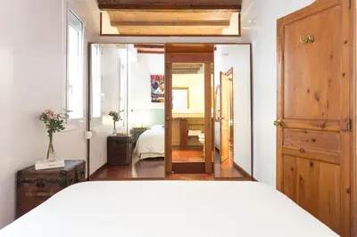 a bedroom with a white bed and a mirror at Casa Cosi Mallorca I in Barcelona