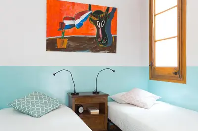two beds in a room with a painting on the wall at Casa Cosi Mallorca I in Barcelona
