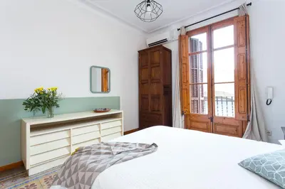 a white bedroom with a bed and a window at Casa Cosi Mallorca I in Barcelona