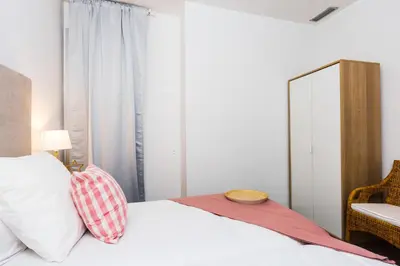 a bedroom with a bed with a mirror and a chair at Apartamentos Cornellalux 2 in Cornellà de Llobregat
