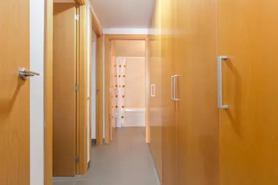 a corridor of a hallway with wooden doors and a room at Apartamentos Cornellalux 2 in Cornellà de Llobregat