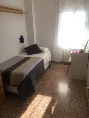 a bedroom with a bed and a large window at The Hollidays Apartment in Calella