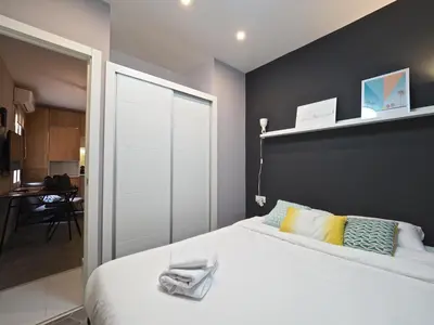a bedroom with a white bed with a black wall at Torrassa Cozy Apartment by Olala Homes in Hospitalet de Llobregat