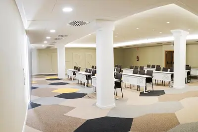 a dining room with tables and chairs and windows at Golden Hotel Barcelona in Barcelona