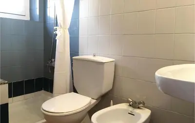 a bathroom with a white toilet and a sink at Lovely Apartment In Pineda De Mar in Pineda de Mar