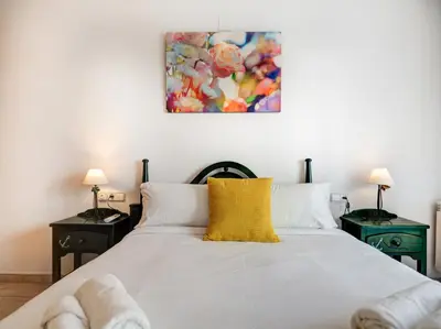 a bedroom with a white bed with a yellow pillow at Parellades Apartment by Hello Homes Sitges in Sitges
