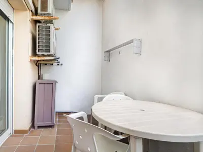 a room with a table and chairs and an air conditioner at Parellades Apartment by Hello Homes Sitges in Sitges
