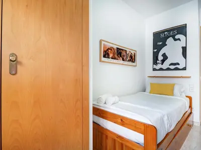 a bedroom with a bed next to a door at Parellades Apartment by Hello Homes Sitges in Sitges