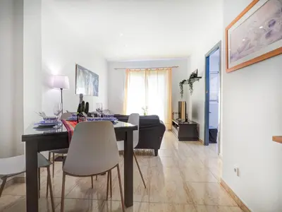 a living room with a dining room table and a living room at Parellades Apartment by Hello Homes Sitges in Sitges