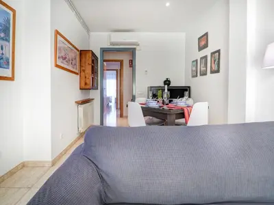 a bedroom with a bed and a table with chairs at Parellades Apartment by Hello Homes Sitges in Sitges