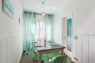 a dining room with a table and green chairs at Vilasardemarlux1 in Vilassar de Mar