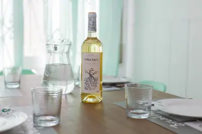 a bottle of wine sitting on a table with glasses at Vilasardemarlux1 in Vilassar de Mar