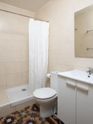 a white bathroom with a toilet and a sink at CasaNova Guest House in Barcelona
