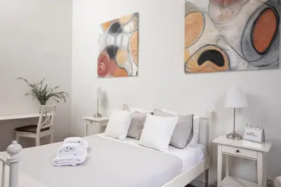 a white room with a bed and two paintings on the wall at CasaNova Guest House in Barcelona