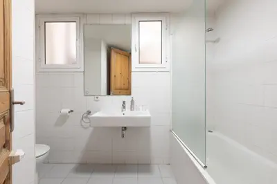 a white bathroom with a sink and a mirror at CasaNova Guest House in Barcelona