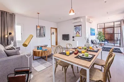 a living room with a table and chairs and a couch at Sweett - Pedrera Department 24 in Barcelona