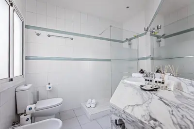a white bathroom with a sink and a toilet at Sweett - Pedrera Department 24 in Barcelona