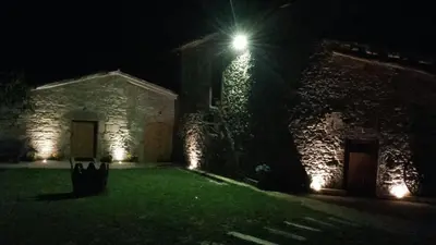 a building with a light on the side of it at night at Hostal Sant Roc in Montseny