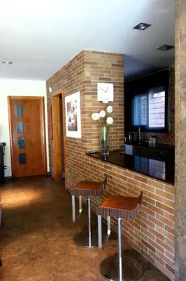 a bar with two chairs and a brick wall at Can Vinyals Holiday Home in Castellar