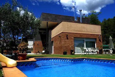a house with a swimming pool in front of a house at Can Vinyals Holiday Home in Castellar