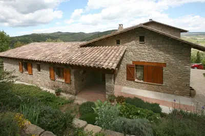 a small stone house with a roof at Entre Roures in Moià
