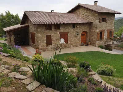 a large stone house with a yard with a yard at Entre Roures in Moià
