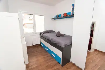 a small bed in a room with a window at Vilamarlux I in Vilassar de Mar