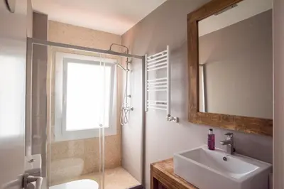 a bathroom with a sink and a shower and a mirror at Vilamarlux I in Vilassar de Mar