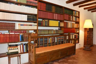 a library with a wooden bench in front of books at Masia Sitges Mas Peirot Geniune Farmhouse 20 min walk from beaches 60 Heactares of Wine Fields Garden AC Until 18 people in Cubelles