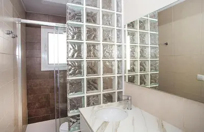 a bathroom with a sink and a glass wall at The Gran Via Penthouse in Barcelona